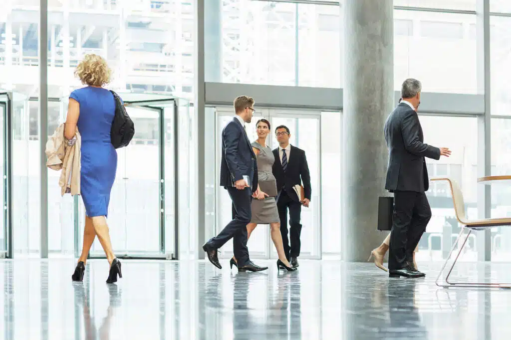 business people walking into an open plan office lobby