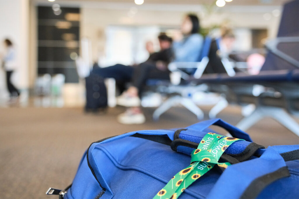 What is a Lanyard Used for? 13 Core Uses that Will Have You Reaching for this Widely Underestimated Tool 3 a sunflower lanyard tied to a travel bag on the floor of an airport