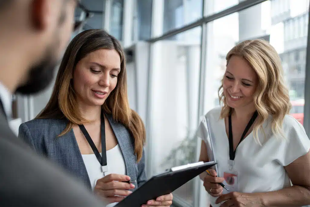 What is a Lanyard Used for? 13 Core Uses that Will Have You Reaching for this Widely Underestimated Tool 2 two women using lanyards in the workplace as they read a clipboard