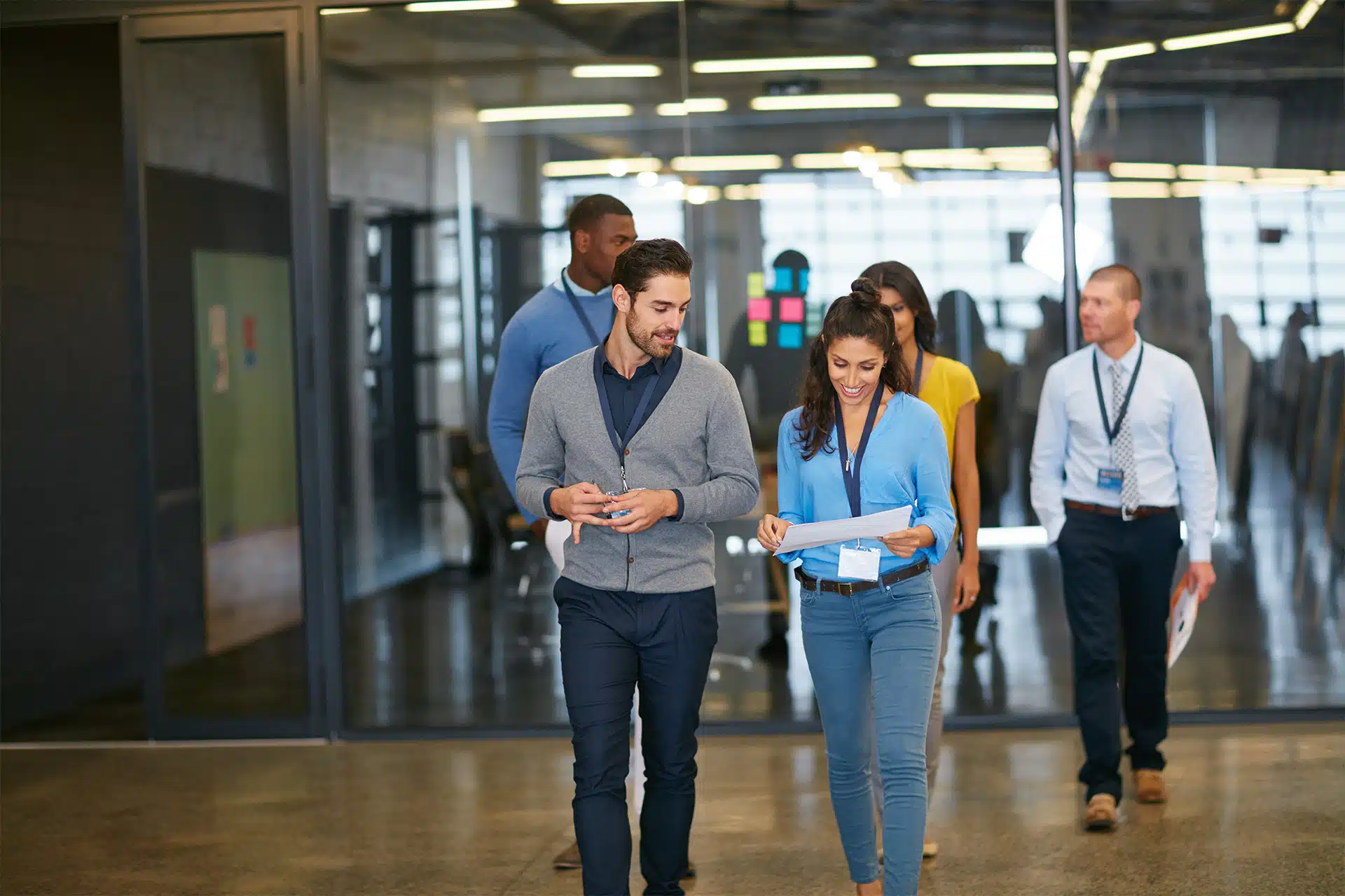 A Crash Course on Employee Identification: Benefits, Uses and Best Practices 3 a corporate team leaving the front of the office together all wearing ID badges on lanyards
