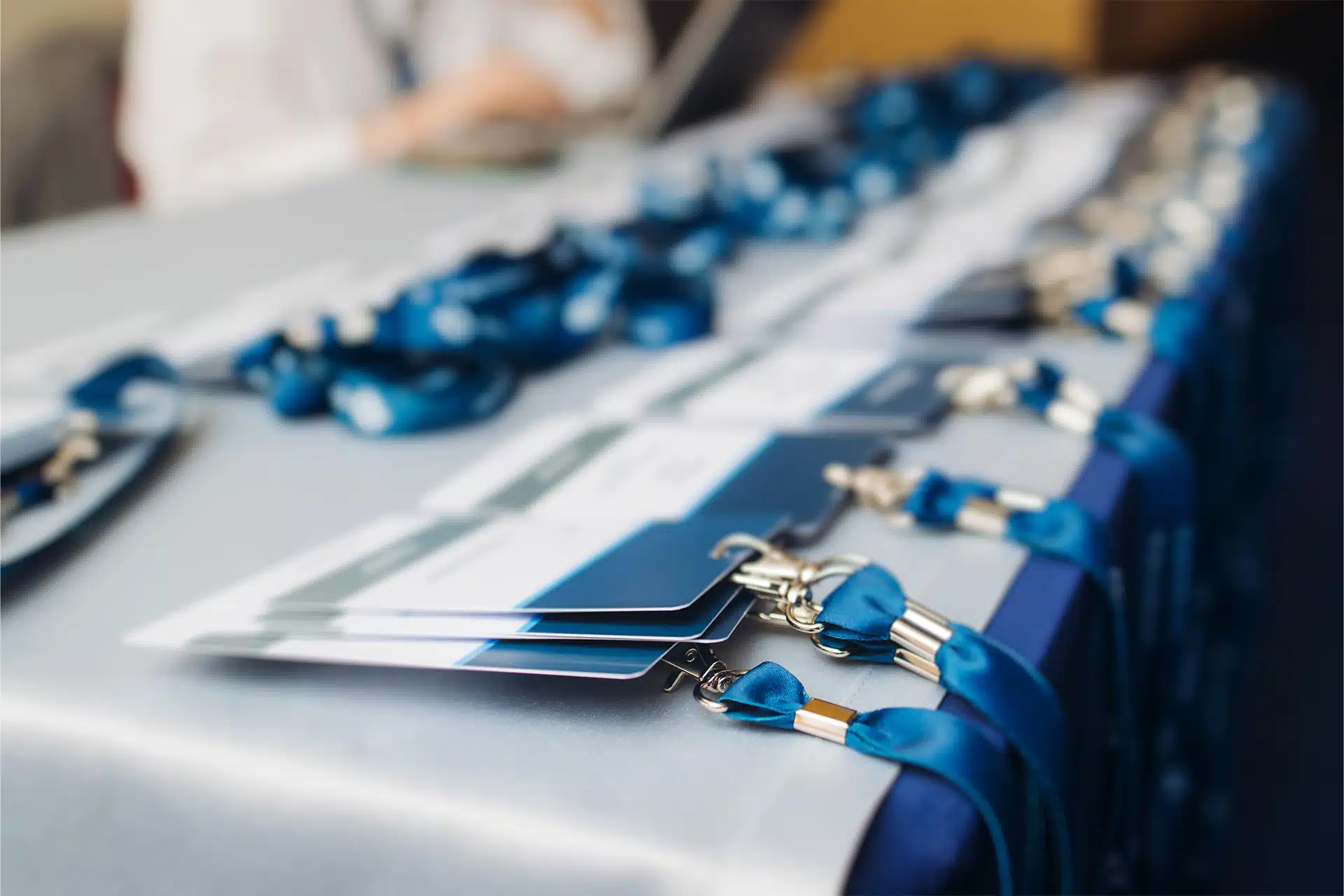 Different Types Of Lanyard Clips: Which Is Right For Your Organisation? 3 event lanyards with guest passes lined up on a stall